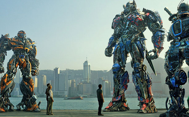 Left to right: Hound, Bingbing Li plays Su Yueming, Stanley Tucci plays Joshua Joyce, Bumblebee, Jack Reynor plays Shane Dyson, Nicola Peltz plays Tessa Yeager, Mark Wahlberg plays Cade Yeager, Optimus Prime, Drift, and Crosshairs in TRANSFORMERS: AGE OF EXTINCTION, from Paramount Pictures.